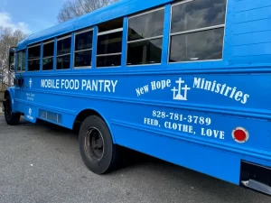 A blue mobile food pantry bus with white lettering from A Signco in Conover, NC.